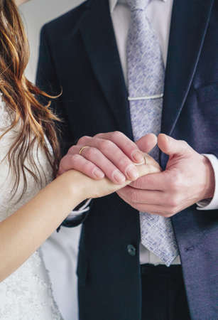 Man holding woman's hand with engagement ring, wedding dayの写真素材