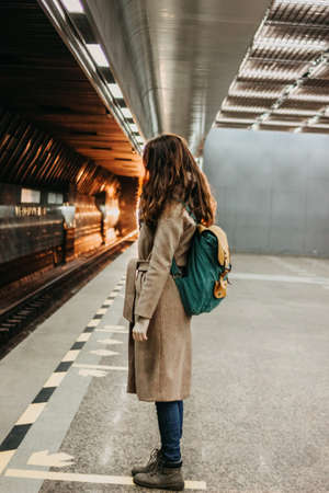 Young woman curly red head girl traveller with backpack and map in subway stationの写真素材