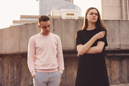 Unhappy young couple of friends, teenagers, students at city street, relationship difficulties conceptの写真素材