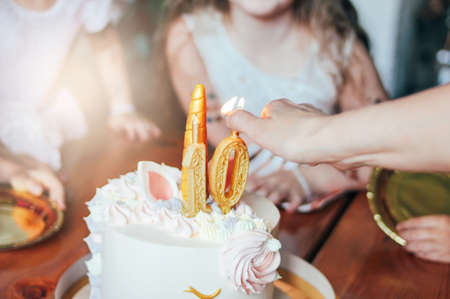 Children's hands little girls reach for the cake. Big beautiful cake unicorn on ten years birthday...