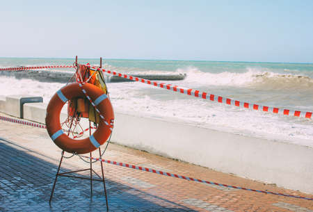 Orange lifeline on the background of a closed empty beach in a stormの写真素材