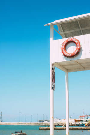 Sochi, Russia - August, 05, 2019. White booth tower with lifebuoy on the shore of Black sea