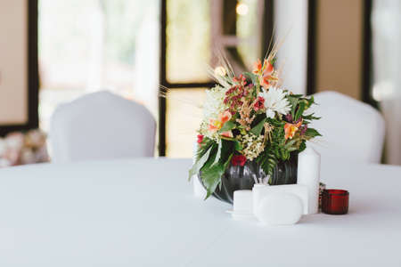 Bouquet of different flowers in a vase on the table, preparing for event, weddingの写真素材