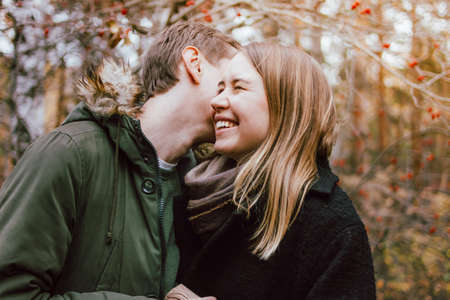 Happy young couple in love friends dressed in casual style walking together on nature park forest in...