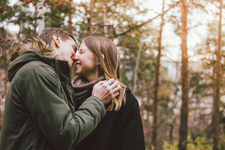 Happy young couple in love friends dressed in casual style walking together on nature park forest in the cold season, family advenure travelの写真素材