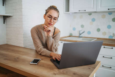 Beautiful smiling young woman fair long hair girl in glasses wearing in the cozy knitted sweater...
