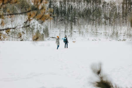 The young couple with dog haski at the forest nature park in winter. Travel adventure concept