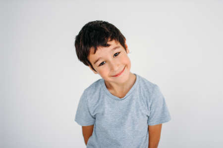 Cute smiling tween boy looking at camera on the white backgroundの写真素材