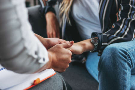Woman support and help concept. Women hold each other's hands sitting in the modern loft office