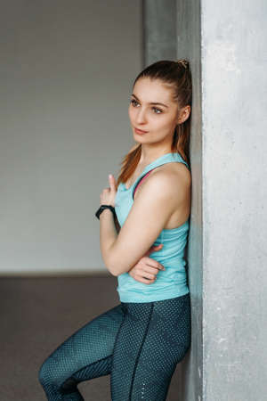 Attractive fit smiling young woman sport wear fitness girl model portrait at home loft studio workout classの写真素材