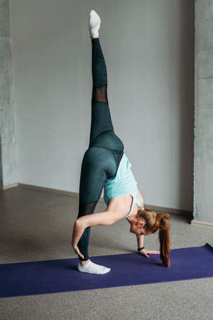 Attractive fit young woman sport wear fitness girl doing stretching at home studio workout class