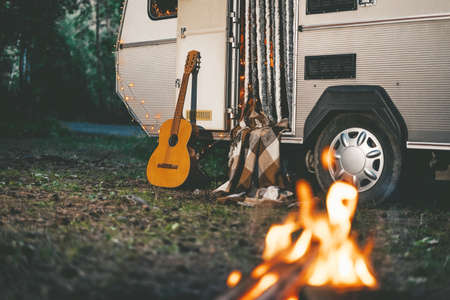 Camper van with gitar and fire place parking at forest at night, family vacationsの写真素材