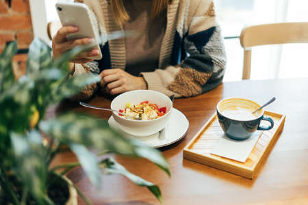 Young smiling blonde woman in casual clothing having lunch at the cafe