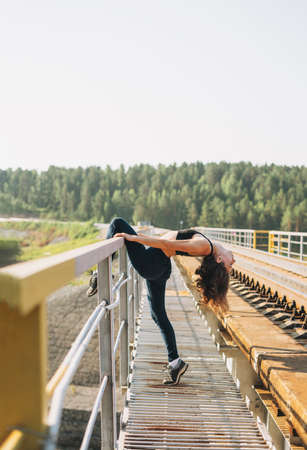 Young  woman stands on bridge on railway tracks
