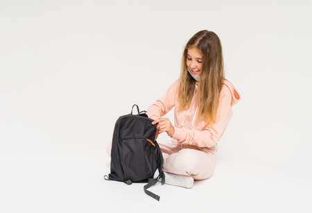 Teen girl in pink hoodie in face mask girl with backpack isolated on white background