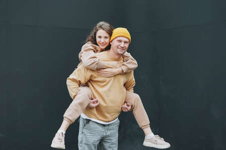 Happy stylish young family couple in love hipsters having fun against glass wallの写真素材