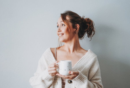 Attractive friendly smiling brunette woman middle age using laptop at home cozy vibes winter seasonの写真素材