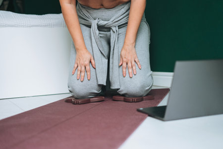 Beautiful smiling brunette young woman plus size body positive using laptop in kitchen at homeの写真素材