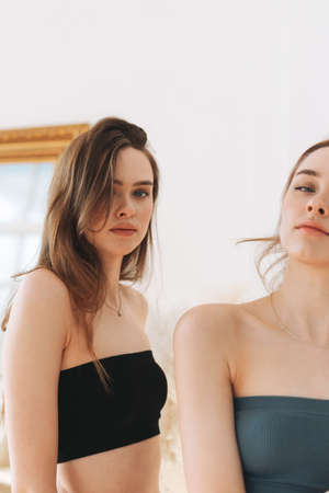 Fashion beauty models two sisters twins beautiful girls with long hair in sport seamless ribbed...