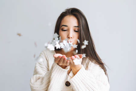 Young asian woman in white holding in hands Large round chocolate almond cake on table with New Year serving, christmas white scandinavian interior, birthday girlの写真素材