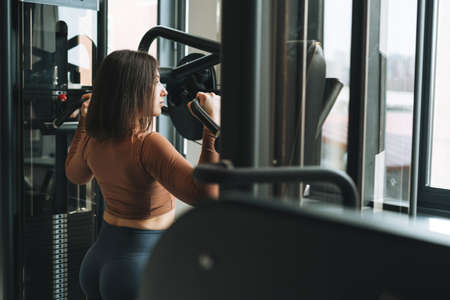 Young brunette woman in black wear engaged boxing training in fitness club gym