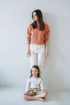 Vertical portrait in natural tones of Young parent woman mother with child girl in the empty roomの写真素材