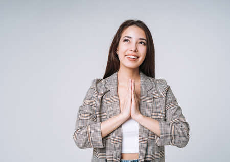 Young unhappy asian business woman with long hair in suit and jeans holding her hands on head on...