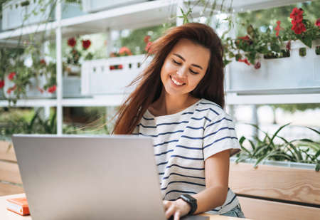 Portrait of young woman student with long hair in city parkの写真素材