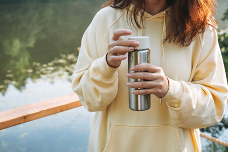 Adult smiling brunette woman forty years using mobile phone in cafe at city streetの写真素材
