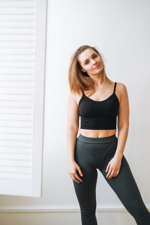 Young slim woman in sportwear dancer at bright studioの写真素材