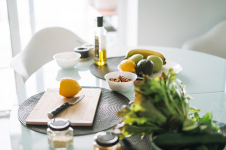 Fresh green fruits and vegetables on table while cooking in kitchen at homeの写真素材