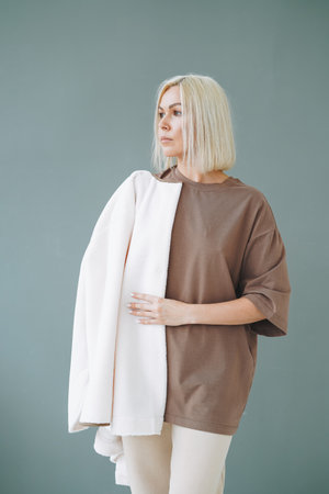 Portrait of young blonde woman in sportswear on background of gray wallの写真素材