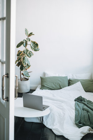 Opened laptop in scandinavian modern cozy bright interior in bedroom at homeの写真素材