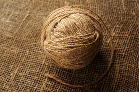 A tuft of woolen threads for knitting and weaving on a background of rough mattingの写真素材