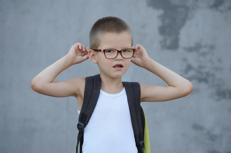The senior boy in a large family is going to school and showing his drawings and a school backpackの写真素材