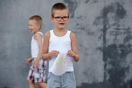 The senior boy in a large family is going to school and showing his drawings and a school backpackの写真素材