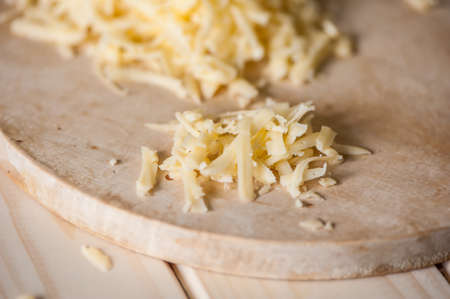 grated cheese on a wooden board and floatの写真素材