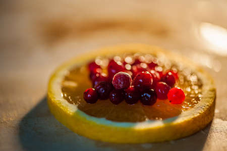 orange with cranberries on a wooden backgroundの写真素材