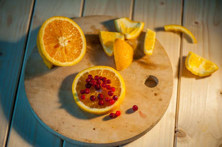 orange with cranberries on a wooden backgroundの写真素材