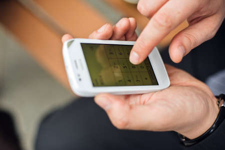 Man's hands write down the phone number in the phone