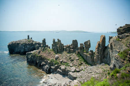 The rocks above the sea and seagullsの写真素材