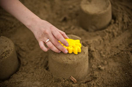 Hand making a sand mold using molds, tools for children to play in the sandの写真素材