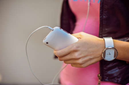 Women's hands with a mobile phone and headsetの写真素材