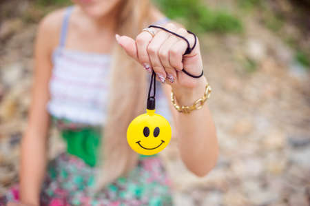 Girl holding a yellow ball with a smiling faceの写真素材