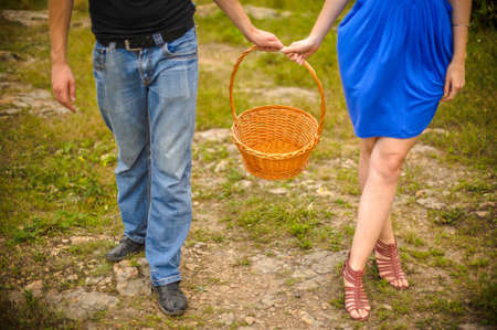 A young couple standing with an empty basket to harvestの写真素材