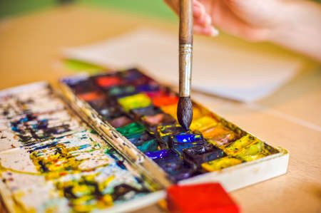 Brush taps in blue paint, gaining paint, watercolorの写真素材