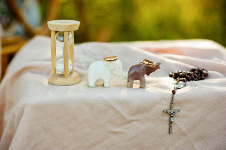 Hourglass, elephants wedding rings and a cross