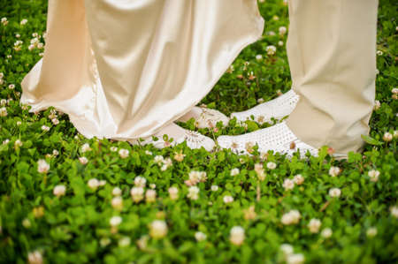 The feet of men and women in white on the cloverの写真素材