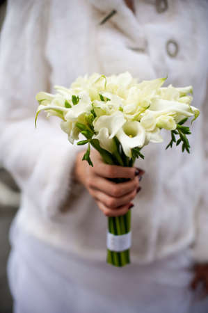 White bouquet in a hand of the brideの写真素材