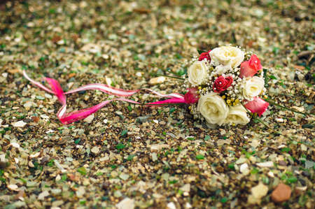 Pink and white wedding bouquet on the rocky beachの写真素材